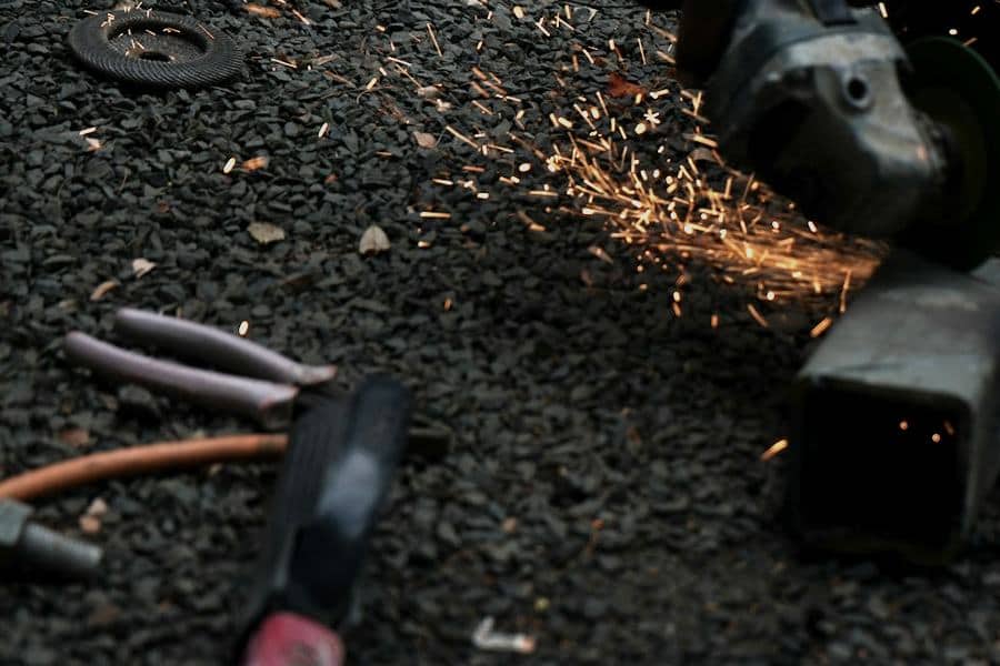 Avuç taşlamanın kesme diski metal profili keserken çıkan kıvılcımlar; yanda kullanılmış bir kesme taşı.